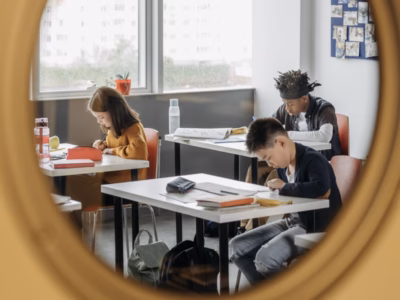Kinder lernen im Klassenzimmer durch ein Fenster gesehen.